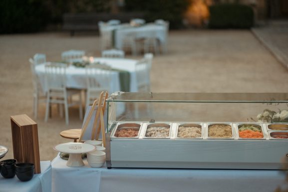 Buffet de desserts avec plusieurs options, tables blanches en arrière-plan.